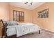 Bedroom featuring neutral walls, a queen-size bed, and wooden shuttered window at 14022 W Hope Dr, Surprise, AZ 85379