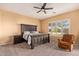Cozy bedroom features a rustic wood bed frame, ceiling fan, and neutral carpet at 14022 W Hope Dr, Surprise, AZ 85379