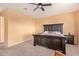 Cozy bedroom features a rustic wood bed frame, ceiling fan, and neutral carpet at 14022 W Hope Dr, Surprise, AZ 85379