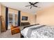 Comfortable bedroom features ceiling fan, glass doors, and neutral carpet at 14022 W Hope Dr, Surprise, AZ 85379