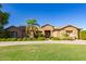 Charming single-story home boasting a lush green lawn, mature trees, and inviting curb appeal on a sunny day at 14022 W Hope Dr, Surprise, AZ 85379