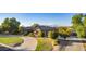 Inviting home with a circular driveway, lush landscaping, mature trees and 3-car garage at 14022 W Hope Dr, Surprise, AZ 85379