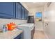 Laundry room with blue cabinets, and stainless steel washer and dryer at 14022 W Hope Dr, Surprise, AZ 85379