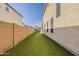 A long, narrow backyard with artificial turf and privacy walls is perfect for low-maintenance outdoor living at 14874 W Laurel Ln, Surprise, AZ 85379