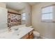 Bathroom features a white vanity, framed mirror, wood blinds, and tub with shower curtain at 14874 W Laurel Ln, Surprise, AZ 85379