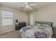 Cozy bedroom with purple floral comforter, wood blinds, and a back door to the patio at 14874 W Laurel Ln, Surprise, AZ 85379
