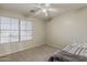 Cozy bedroom features a large window, neutral paint, ceiling fan, and carpeted floors at 14874 W Laurel Ln, Surprise, AZ 85379