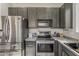 Modern kitchen showcases stainless steel appliances, dark cabinets, and ample counter space for cooking and entertaining at 14874 W Laurel Ln, Surprise, AZ 85379