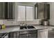 The modern kitchen features dark cabinets, a stainless steel dishwasher, and lots of counter space and storage at 14874 W Laurel Ln, Surprise, AZ 85379