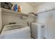 Functional laundry room features front load washer and dryer, upper shelf storage and hanging rod at 14874 W Laurel Ln, Surprise, AZ 85379