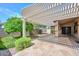 The covered back patio features a pergola, stone flooring, and views of the surrounding yard at 15035 W Indianola Ave, Goodyear, AZ 85395