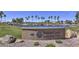 PebbleCreek Model Home Village entrance with a pond, palm trees, and well-maintained landscaping at 15035 W Indianola Ave, Goodyear, AZ 85395