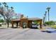 Community entrance gate featuring desert landscaping and a car entering the PebbleCreek community at 15035 W Indianola Ave, Goodyear, AZ 85395