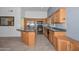Functional kitchen boasts wood cabinets, granite countertops, and stainless steel appliances at 15035 W Indianola Ave, Goodyear, AZ 85395