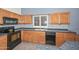 Close-up of the kitchen featuring wooden cabinets, granite countertops, and modern appliances at 15035 W Indianola Ave, Goodyear, AZ 85395