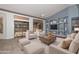 Spacious living area with bright windows, plush seating, and custom shelving offers a relaxing and stylish ambiance at 15035 W Indianola Ave, Goodyear, AZ 85395
