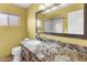 Inviting bathroom with a granite countertop, a large mirror, and a toilet at 15619 N 58Th Ave, Glendale, AZ 85306