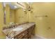 Charming bathroom featuring a vanity with granite countertop, decorative mirror, and elegant lighting at 15619 N 58Th Ave, Glendale, AZ 85306