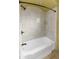 Bathroom featuring white tiled walls, tub and shower combo with dark hardware at 15619 N 58Th Ave, Glendale, AZ 85306