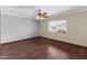 Bright bedroom with hardwood floors, neutral walls, large windows, and a decorative ceiling fan at 15619 N 58Th Ave, Glendale, AZ 85306