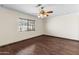 Cozy bedroom with hardwood floors, a ceiling fan, and a window providing plenty of sunlight at 15619 N 58Th Ave, Glendale, AZ 85306