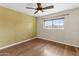 Bedroom with hardwood flooring, ceiling fan, and large window offering ample natural light at 15619 N 58Th Ave, Glendale, AZ 85306