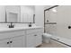 Modern bathroom featuring double sinks, white cabinets, and a glass-enclosed shower at 16575 N Lunar St, Maricopa, AZ 85138