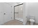Sleek bathroom features glass shower, white door and toilet, and tiled flooring at 16575 N Lunar St, Maricopa, AZ 85138