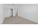 A bright bedroom with neutral carpet, white trim, and a closet with an open door at 16575 N Lunar St, Maricopa, AZ 85138