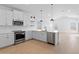 Modern kitchen boasts stainless steel appliances, spacious counters, and modern light fixtures at 16575 N Lunar St, Maricopa, AZ 85138