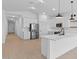 Stylish white kitchen featuring stainless steel appliances, a large island, and modern pendant lights at 16575 N Lunar St, Maricopa, AZ 85138