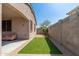A narrow strip of artificial grass lines a block wall creating a maintenance free outdoor space at 1677 W Seagull Ct, Chandler, AZ 85286