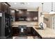 Well-lit kitchen features granite countertops, dark cabinetry, and modern appliances at 1677 W Seagull Ct, Chandler, AZ 85286