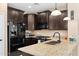 Stylish kitchen features granite countertops, dark cabinetry and stainless steel appliances at 1677 W Seagull Ct, Chandler, AZ 85286