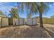 Two metal storage sheds sit in the spacious gravel backyard under the clear blue sky at 1719 E Pinchot Ave, Phoenix, AZ 85016
