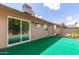 Home's backyard featuring an artificial lawn and exterior doors at 1750 W Mohawk Ln, Phoenix, AZ 85027