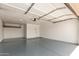 Clean garage with painted floor, automatic door, lighting and shelving at 1750 W Mohawk Ln, Phoenix, AZ 85027
