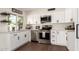 Well-lit kitchen featuring white cabinets, stainless steel appliances and dark hardware at 1750 W Mohawk Ln, Phoenix, AZ 85027