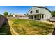 Expansive backyard with lush green grass, a concrete patio, and an exterior elevation view at 1761 E 38Th Ave, Apache Junction, AZ 85119