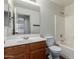 Bright bathroom showcasing a wooden vanity, mirror, toilet, and tiled shower-tub combination at 1761 E 38Th Ave, Apache Junction, AZ 85119