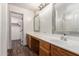 Bathroom with a large vanity, light countertop, dual sinks, mirrors and a shower/tub at 1761 E 38Th Ave, Apache Junction, AZ 85119