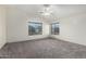 Spacious bedroom with neutral carpet, ceiling fan, and bright natural light from two windows at 1761 E 38Th Ave, Apache Junction, AZ 85119