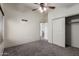 Carpeted bedroom featuring a ceiling fan, closet and view to the hallway at 1761 E 38Th Ave, Apache Junction, AZ 85119
