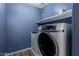Modern laundry room equipped with a front load washer and dryer on a sleek blue wall at 1761 E 38Th Ave, Apache Junction, AZ 85119