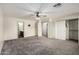Main bedroom features neutral carpet, ceiling fan, multiple doorways, and large closets at 1761 E 38Th Ave, Apache Junction, AZ 85119