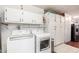 Bright laundry room with white washer, dryer, and ample storage cabinets at 17627 N 104Th Ave, Sun City, AZ 85373