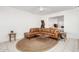 Open living space with a leather sectional, round jute rug, and tiled floors at 17627 N 104Th Ave, Sun City, AZ 85373