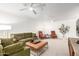 Bright living room featuring modern ceiling fans, a cozy green sofa, and stylish decor at 17627 N 104Th Ave, Sun City, AZ 85373