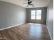 Neutral bedroom with wood-look floors, a ceiling fan and a window, offering ample natural light at 1876 N Parkside Ln, Casa Grande, AZ 85122