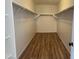 Spacious walk-in closet with wood-look floors and ample shelving for storage at 1876 N Parkside Ln, Casa Grande, AZ 85122